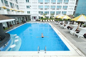 Una piscina al aire libre, sillones reclinables de piscina