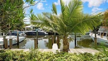 A marina with boats docked, surrounded by lush greenery and a clear sky.
