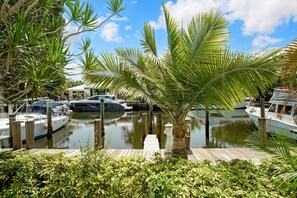 A marina with boats docked, surrounded by lush greenery and a clear sky. - Villa Venezia (Fort Lauderdale)