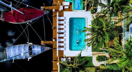 Una piscina al aire libre, sombrillas, sillones reclinables de piscina
