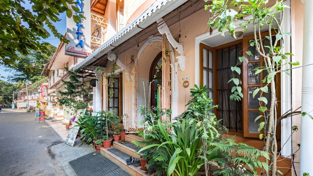 A building with a porch lined with potted plants, a sign reading "VITA Residency," and a door with the number "1387" above it. - Sonnetta Residency (Kochi)