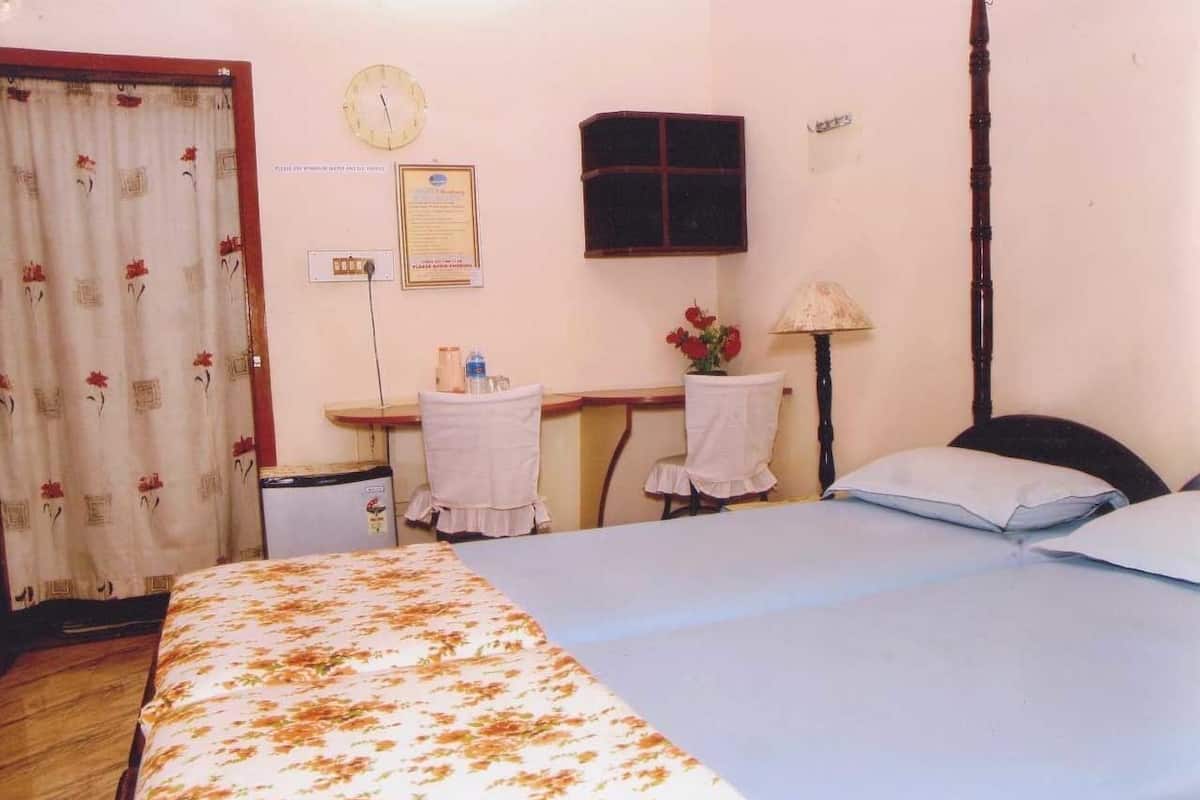 A bedroom with a bed, a desk, a chair, a lamp, and a clock on the wall.