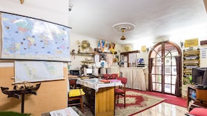 A well-lit office with a large map, a desk with a computer, and a red carpeted area. - Sonnetta Residency (Kochi)