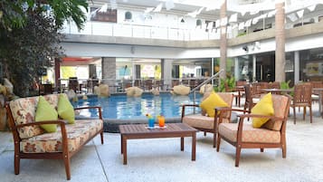 Relax by the pool surrounded by comfortable seating and lush greenery.