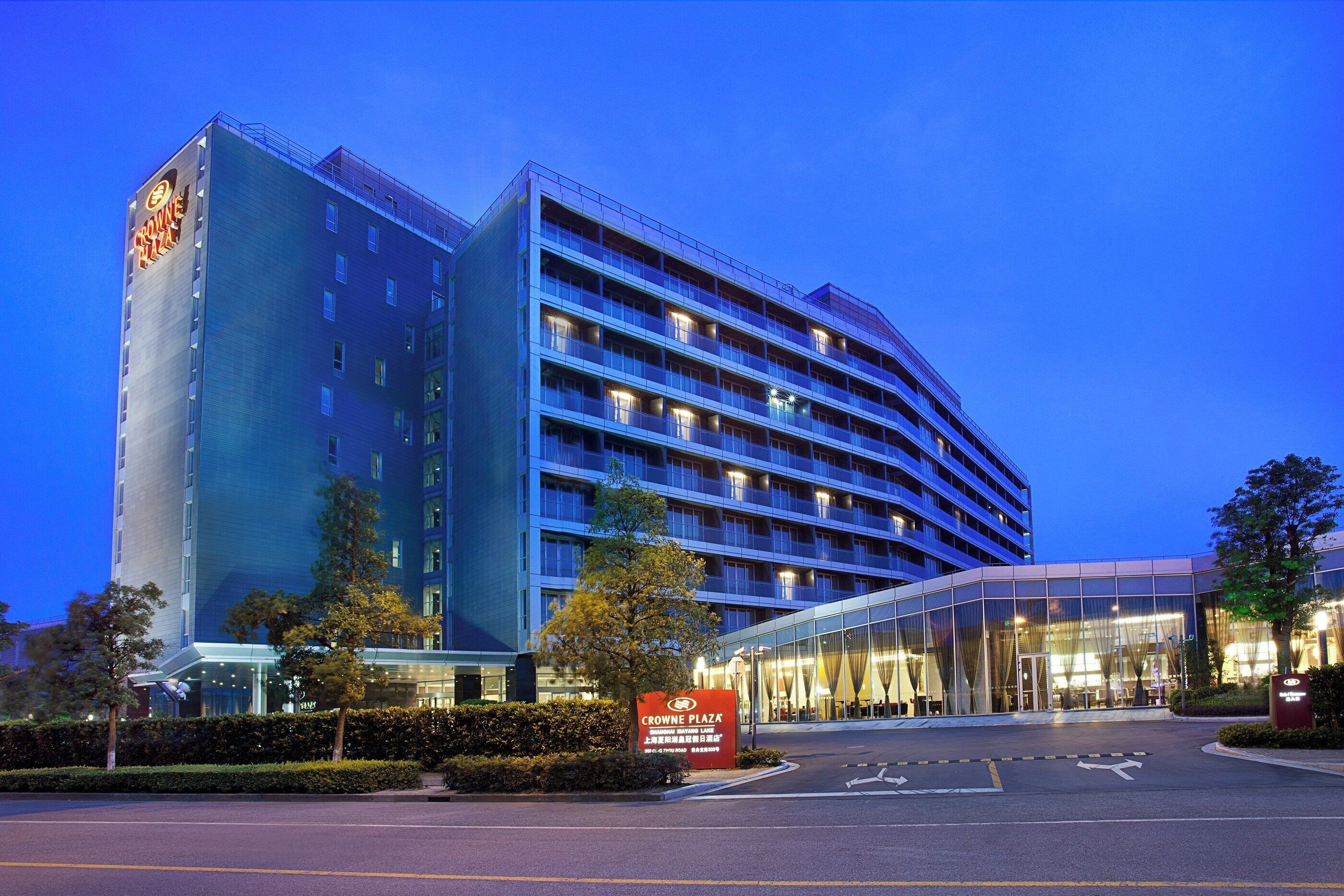 Een meerlaags hotel met een modern ontwerp, met een opvallende ingang en een groot bord.