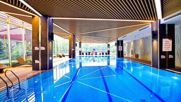 Swimmers can enjoy a rectangular pool with marked lanes in a well-lit area.