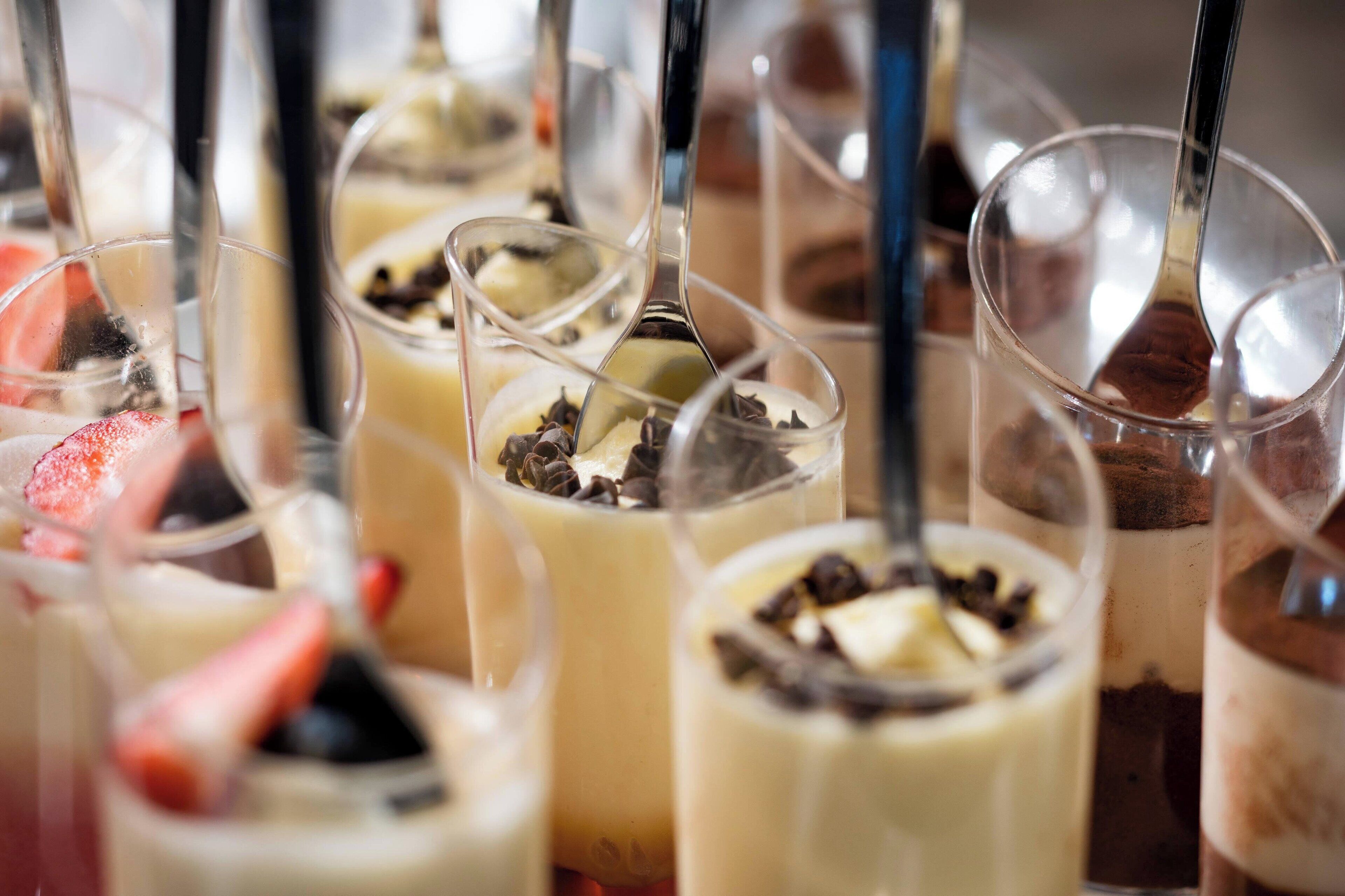 A variety of layered desserts in clear glasses.