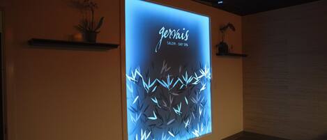 Een muur met een digitaal scherm waarop 'gervaix SALON - DAY SPA' wordt aangeboden.