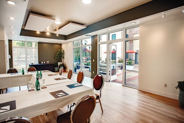A conference room with a long table, chairs, and a large window.