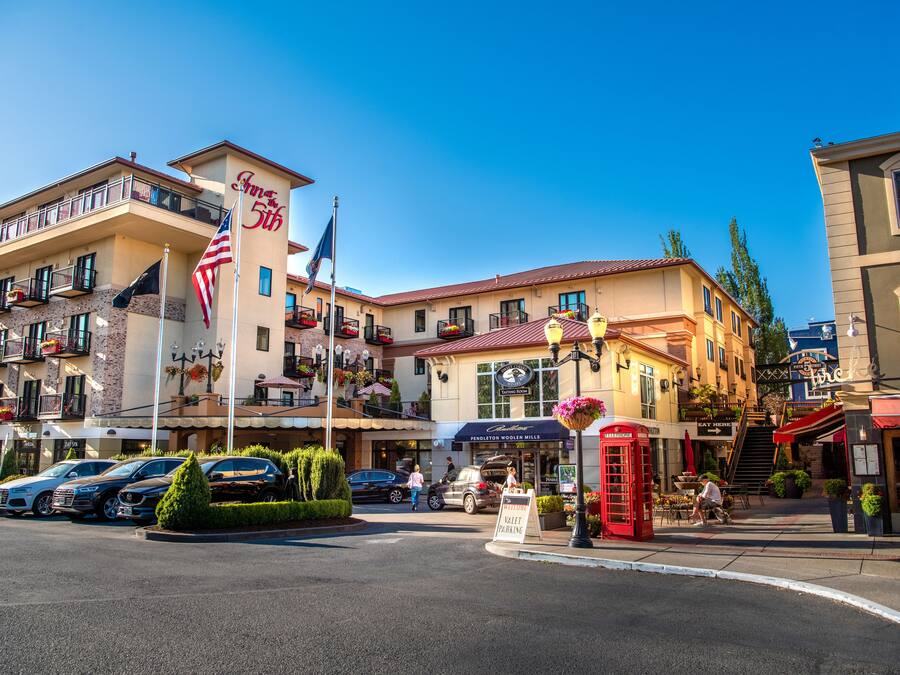 Un hotel con balcón, bandera estadounidense y señalización para servicio de valet premium.