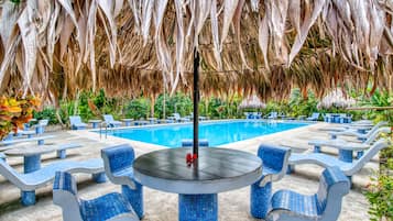 Una piscina al aire libre, camas de piscina gratis, sombrillas