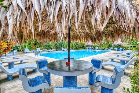 Una piscina al aire libre, camas de piscina gratis, sombrillas