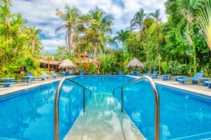 Una piscina al aire libre, camas de piscina gratis, sombrillas