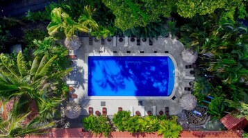 Una piscina al aire libre, camas de piscina gratis, sombrillas
