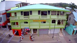 A two-story building with a green roof and balconies, labeled "VENUSHOTEL". - Venus Hotel (San Ignacio)