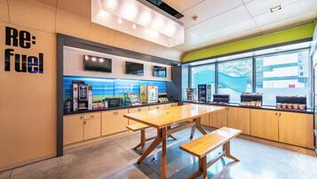 Cozinha moderna com armários de madeira, uma ilha grande com bancada e um aviso 'Re: fuel' na parede.