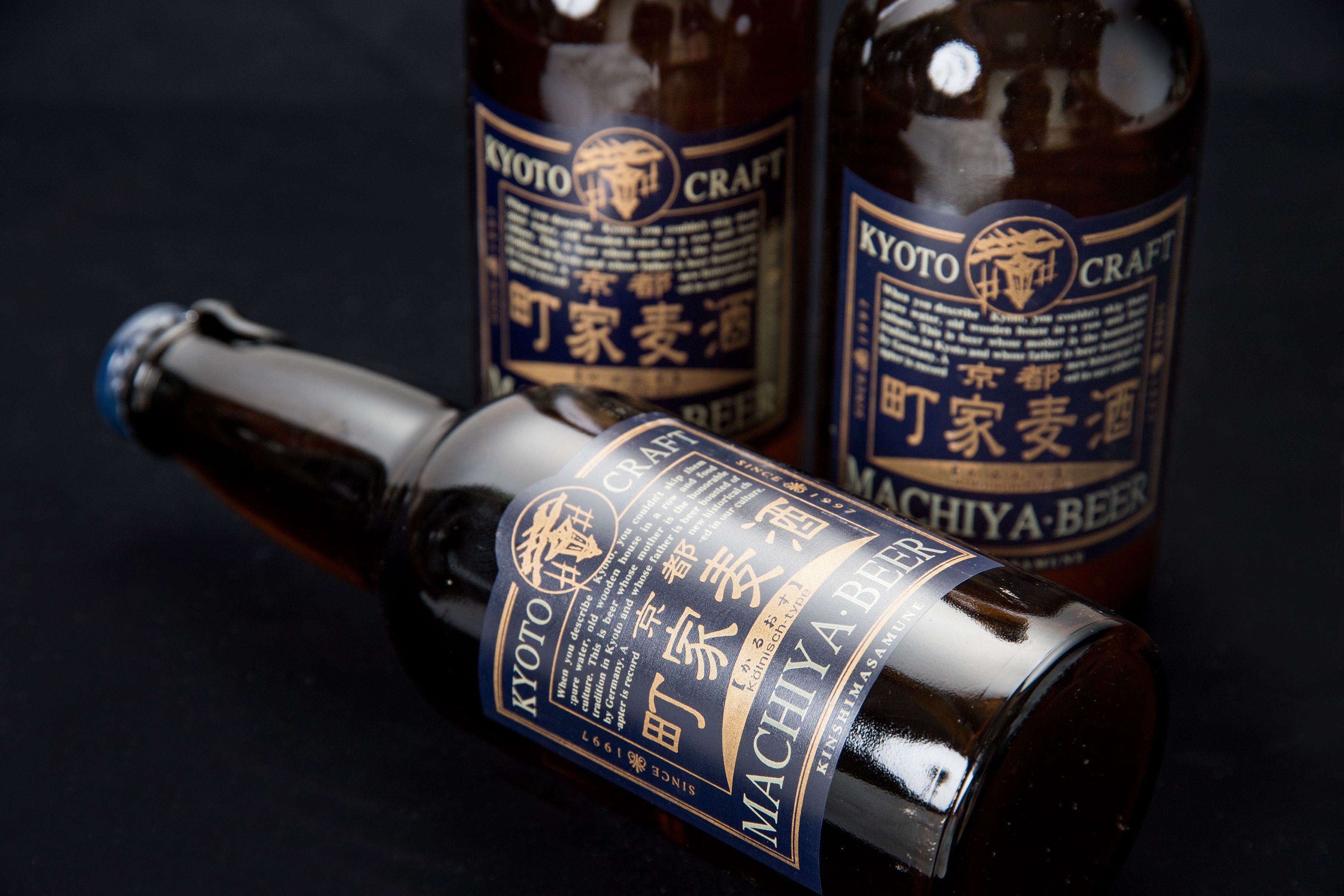 Two bottles of Kyoto Craft beer with labels, one lying on its side and the other upright.