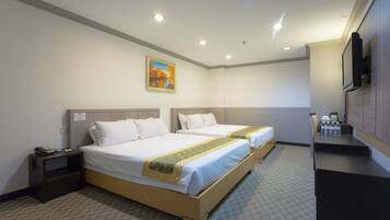 A hotel room with two beds, a desk, a chair, a TV, and a painting on the wall.