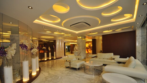 A modern lobby with a marble floor, white sofas, and a central coffee table. - Hotel Kempton (Kolkata)