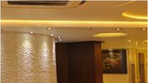 A lobby with a marble floor, a dark wooden door, and two decorative vases. - Hotel Kempton (Kolkata)