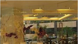 A lobby with marble flooring, tall white vases with flowers, and modern furniture. - Hotel Kempton (Kolkata)