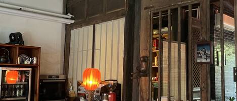 A traditional room with a wooden table, a red lantern, and a coffee machine.