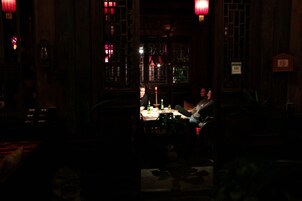A dimly lit room with traditional decor, including wooden furniture and red lanterns.