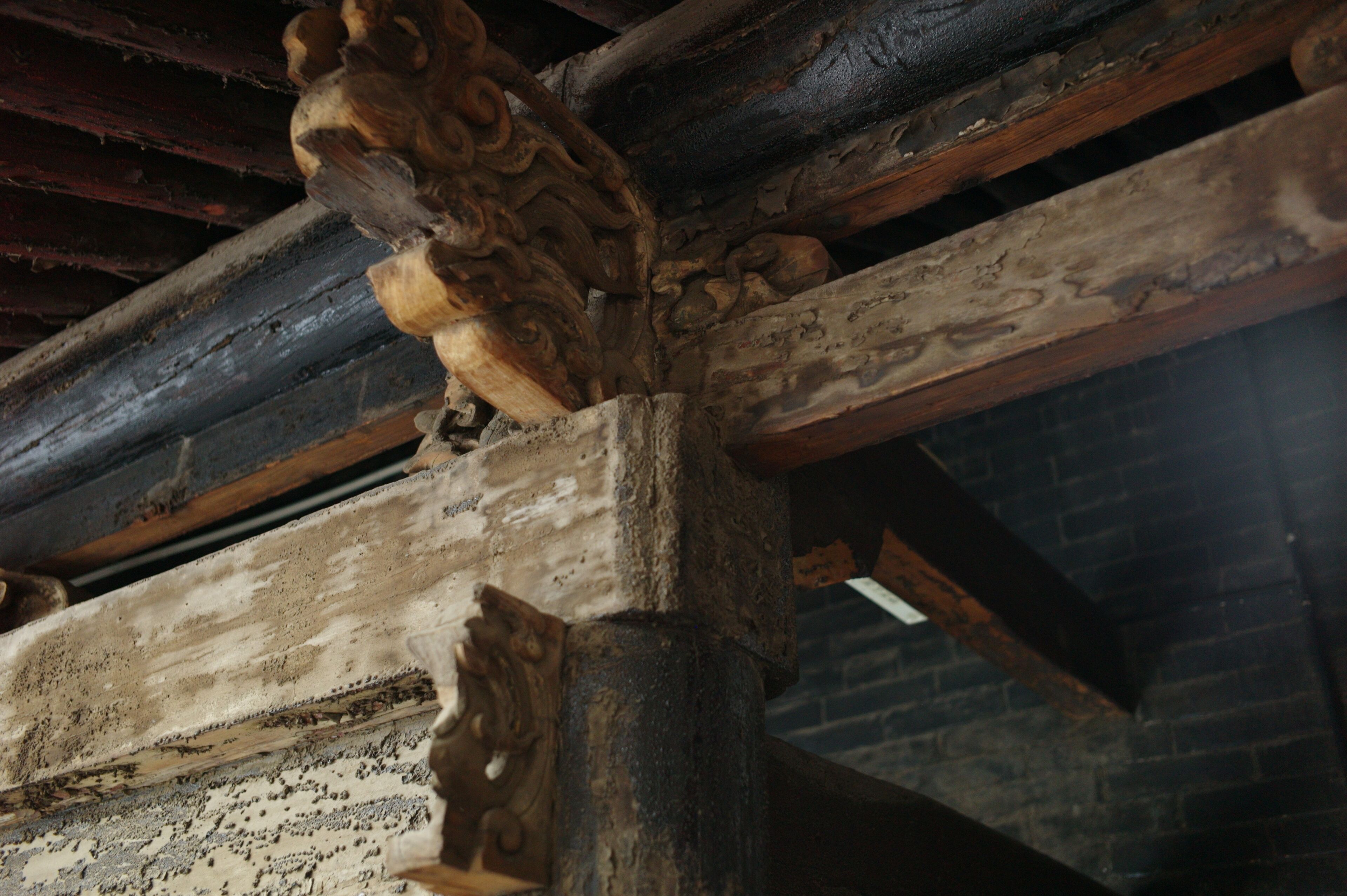 Un gros plan d’une poutre en bois ornée de motifs sculptés, qui fait partie de la structure d’un bâtiment.