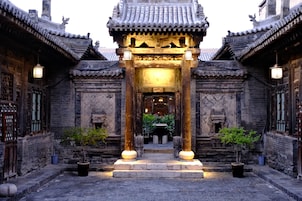 A traditional Chinese building with a central entrance, flanked by two buildings with similar architectural style.