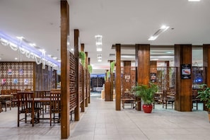 A hotel lobby with wooden pillars, a tiled floor, and a reception desk. - Chinflux Mandarin Hotel (Dongguan)