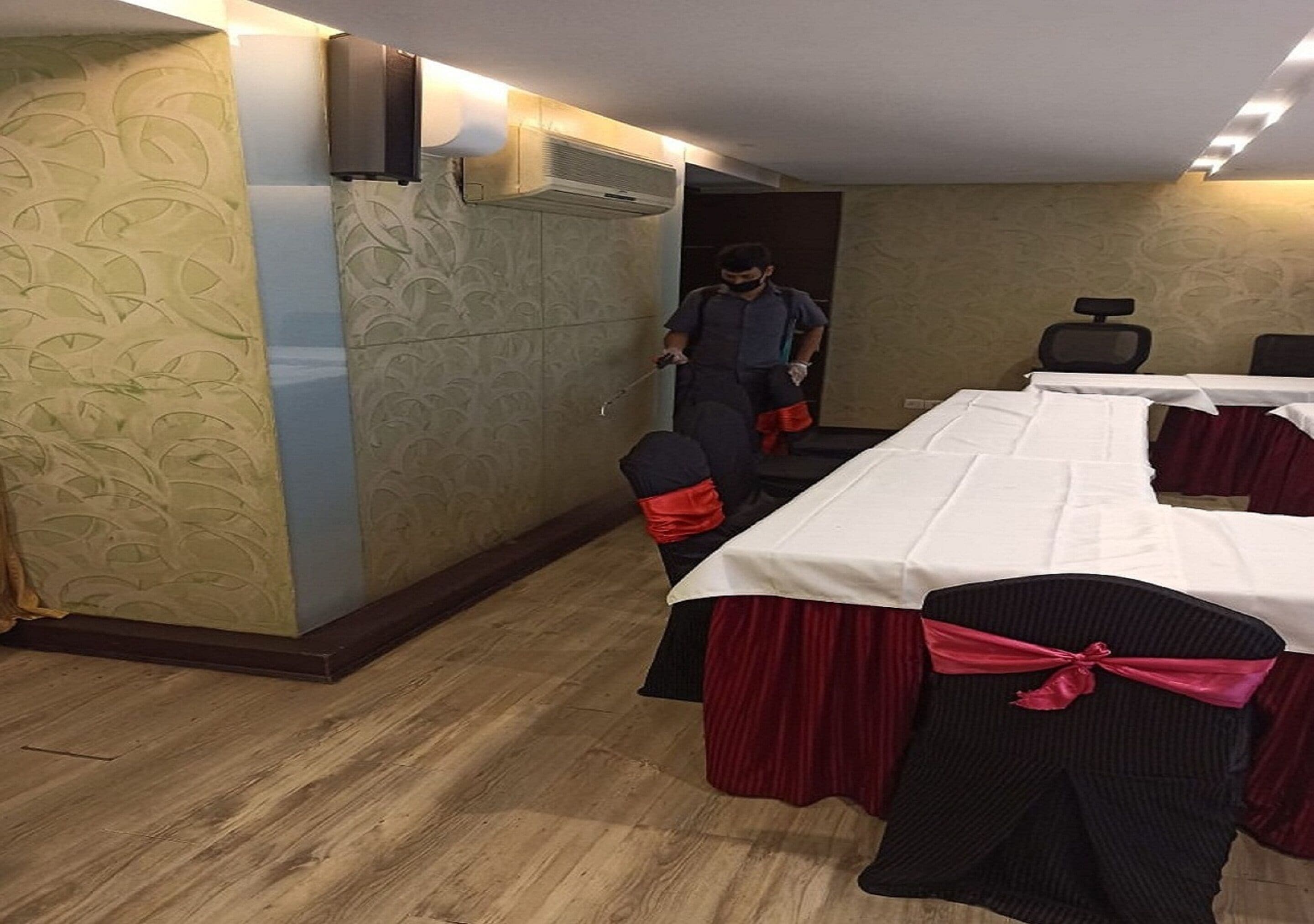 A conference room with a long table, chairs, and an air conditioning unit on the wall.