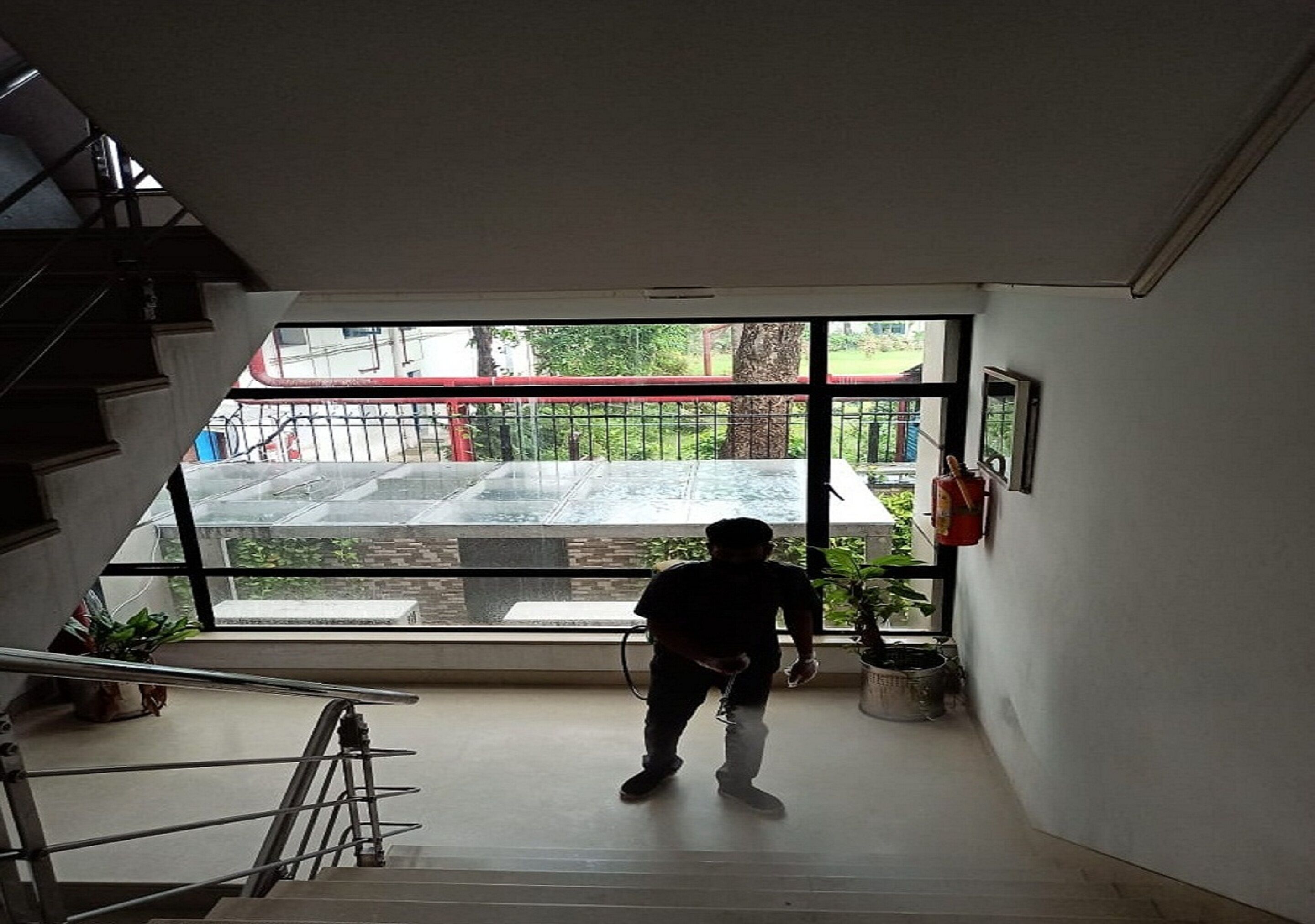 Una escalera conduce a una plataforma con un ventanal grande que da a un patio.