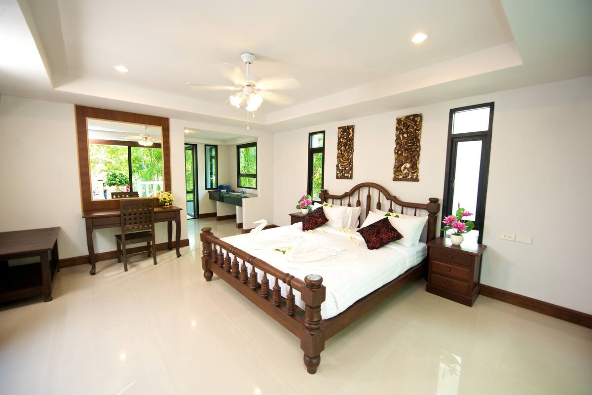 A bedroom with a wooden bed, a desk, and a chair.