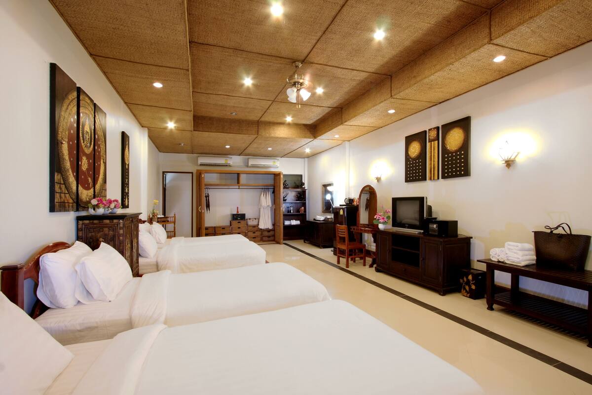 A hotel room with two beds, a desk, a television, and a wardrobe.