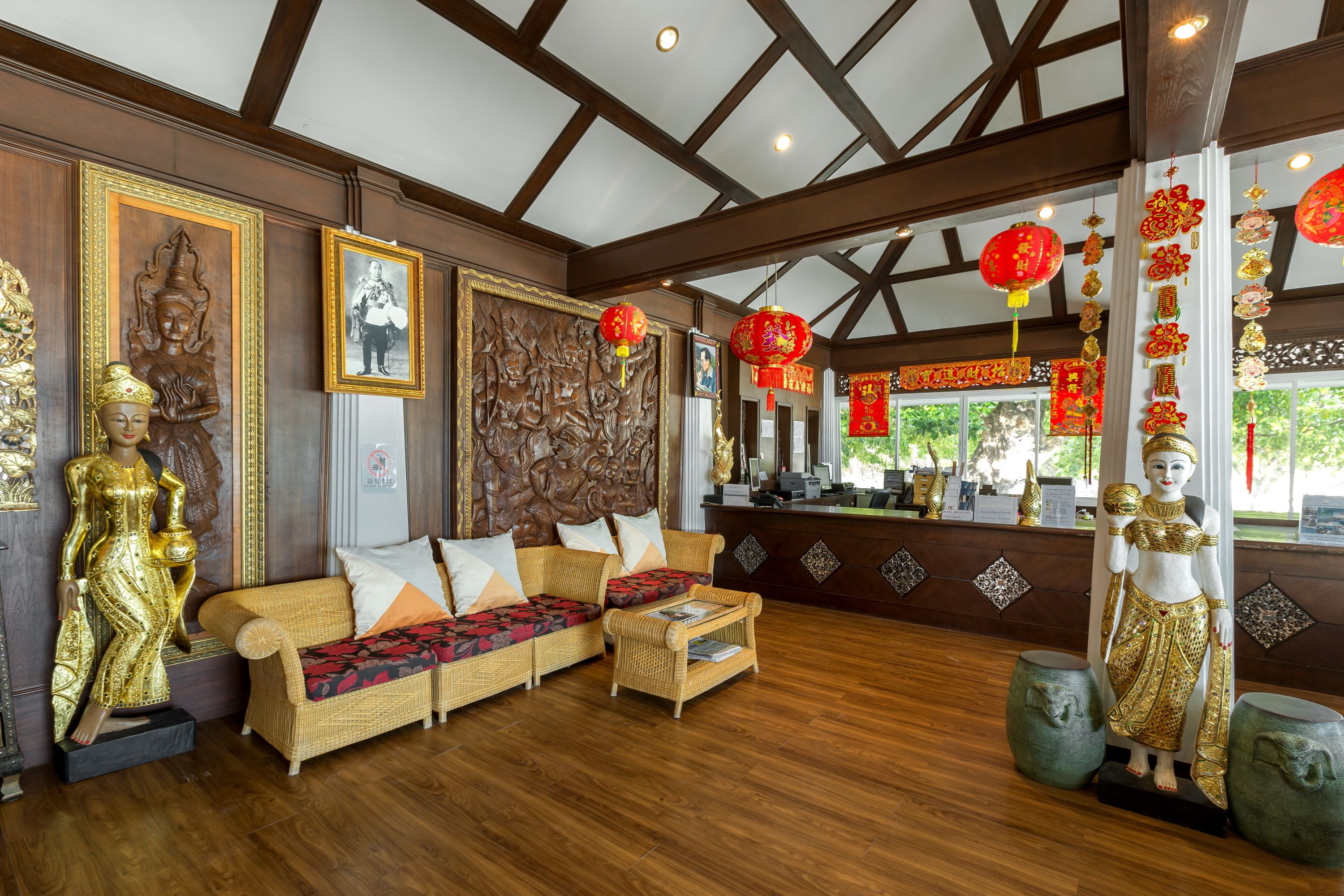 A traditional interior with wooden beams, a sofa set, and decorative statues.