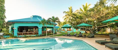 Una piscina al aire libre, sombrillas, tumbonas