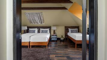 A bedroom with two beds, a nightstand, a lamp, and a decorative wall piece.