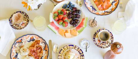 Ein gedeckter Frühstückstisch mit Speisen, einer Blumenvase und verschiedenen Frühstücksartikeln.