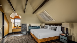 A bedroom with a large bed, a wooden headboard, a nightstand, and a window with blinds. - Corinda Contemporary (Glebe)