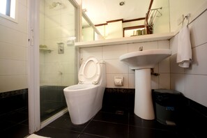 Bathroom features a toilet, sink, and shower enclosure.