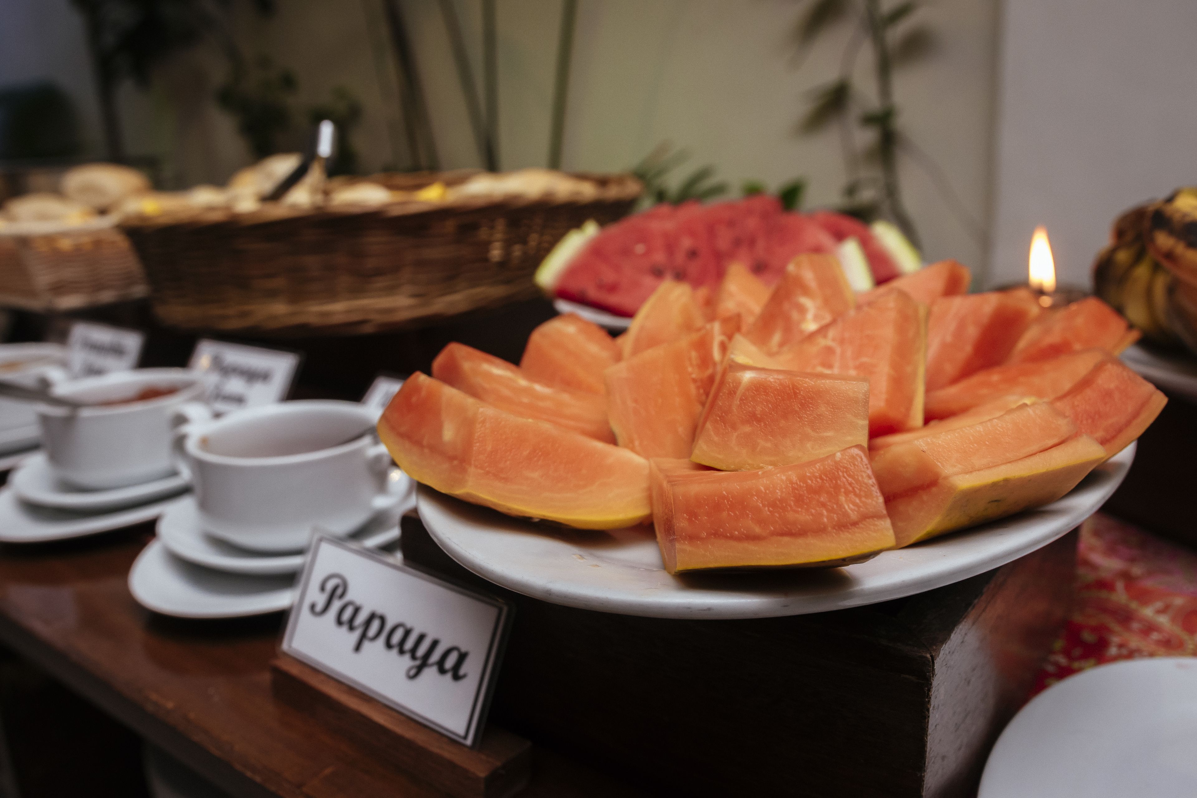 A buffet with various dishes including papaya and other fruits.