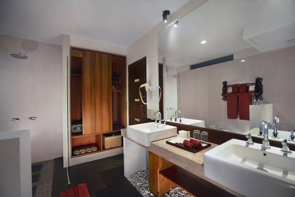 Un baño moderno con dos lavamanos, un espejo grande y un mueble de tocador de madera.