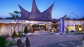 A hotel with a distinctive star-shaped roof, a covered entrance, and a sign indicating amenities.