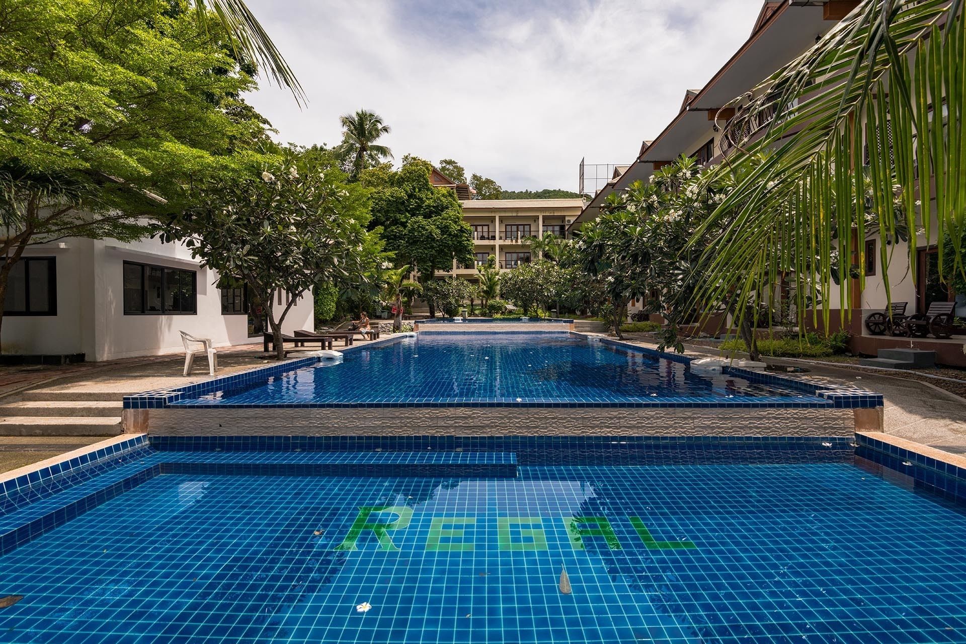 Una piscina con borde de azulejos y la letra 'R' en el centro.