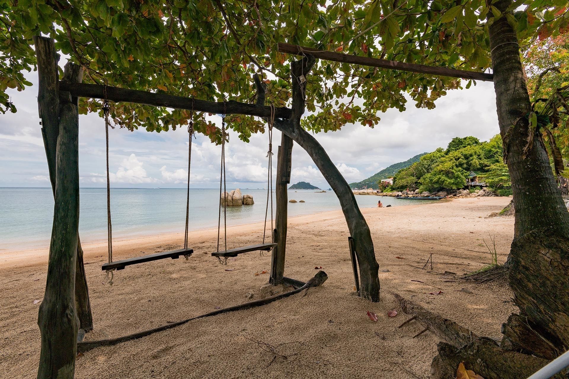 Una playa con un columpio y vistas al mar.