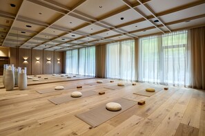A spacious room with wooden flooring, tatami mats, and cushions. - Hotel Alpenhof (Tux)