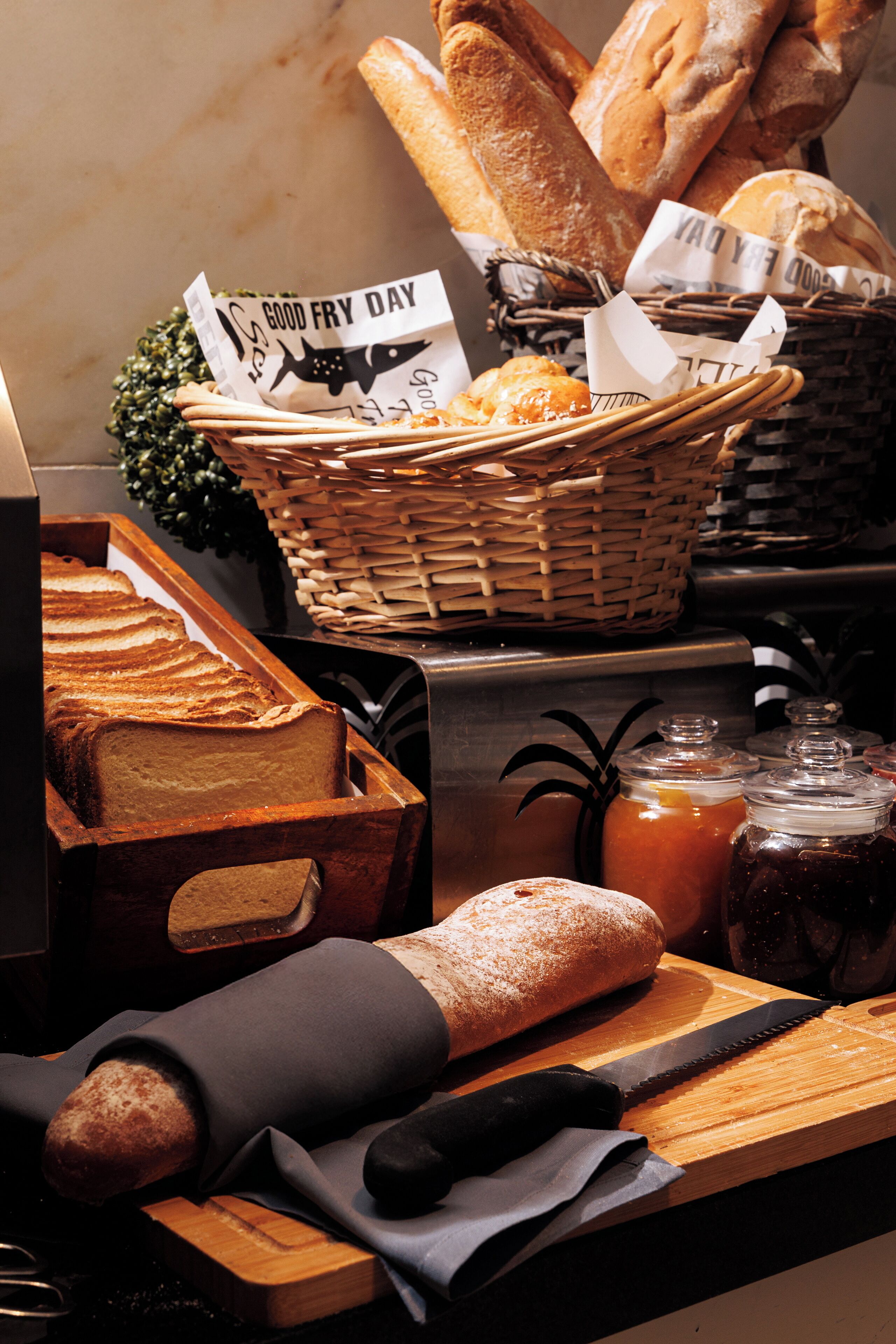 A bakery display with various breads and pastries, a cutting board with a knife, and a basket with a 'Good Fry Day' sign.