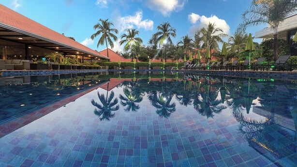 A swimming pool with tiled flooring, palm trees, and lounge chairs. - Riviera Royal Hotel (Conakry)