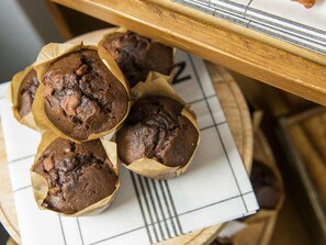 A tray of muffins on a table with a checkered napkin underneath.
