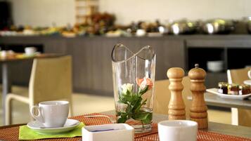 A dining table with a pitcher, salt and pepper shakers, a cup, and a plate with a napkin.